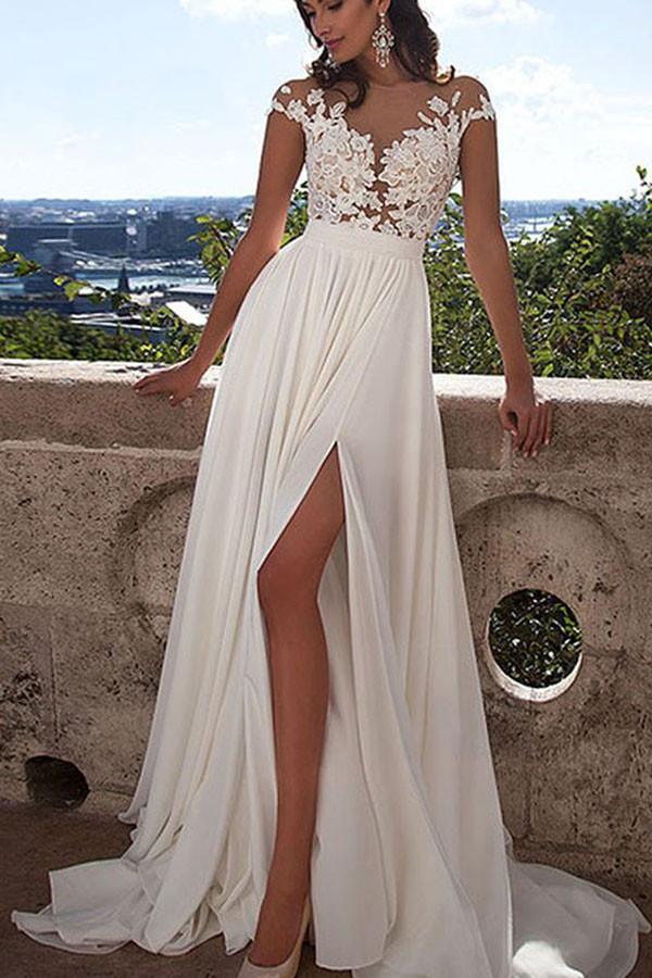 Vestido de novia blanco de encaje con corte en A, abertura frontal y apliques.