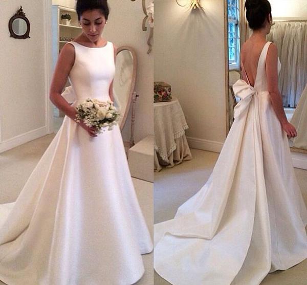 Robe de mariée en satin, col bateau, sans manches, dos nu plongeant en V et traîne. 