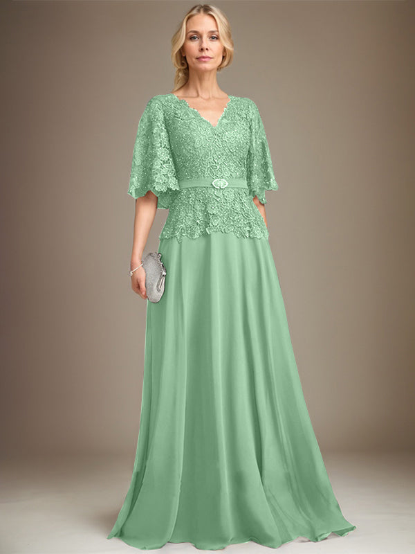 Vestido de novia de corte A, escote en V, largo hasta el suelo, de gasa y encaje, con broche de cristal y pedrería. 