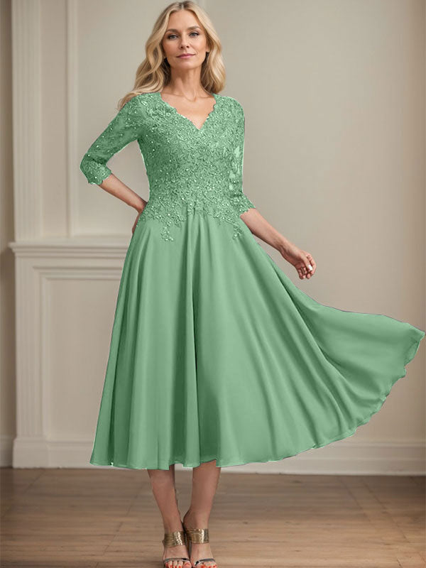 Vestido de corte A, escote en V, largo hasta la rodilla, de gasa, encaje, con lentejuelas y pedrería para la madre de la novia. 