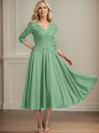 Vestido de corte A, escote en V, largo hasta la rodilla, de gasa, encaje, con lentejuelas y pedrería para la madre de la novia. 