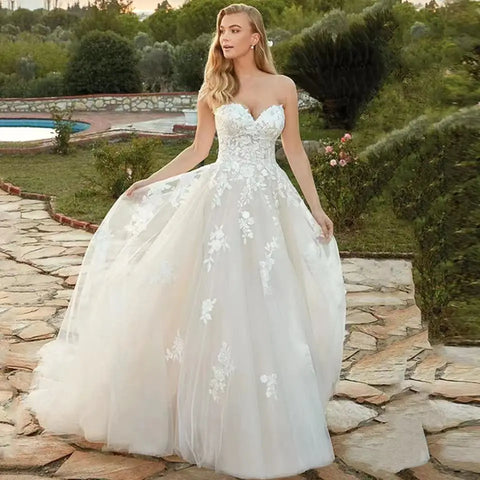 Vestidos de novia color marfil para mujer, estilo playa, colección verano 2023. Corte corazón, línea A, largo hasta el suelo, ilusión, espalda con lazo y apliques de encaje.