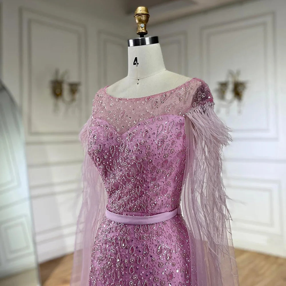 Vestido de noche de sirena con mangas tipo capa rosa estilo Dubai, falda lateral, plumas y cuentas, modelo LA72701 (2025) 