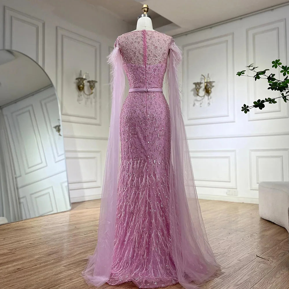 Vestido de noche de sirena con mangas tipo capa rosa estilo Dubai, falda lateral, plumas y cuentas, modelo LA72701 (2025) 