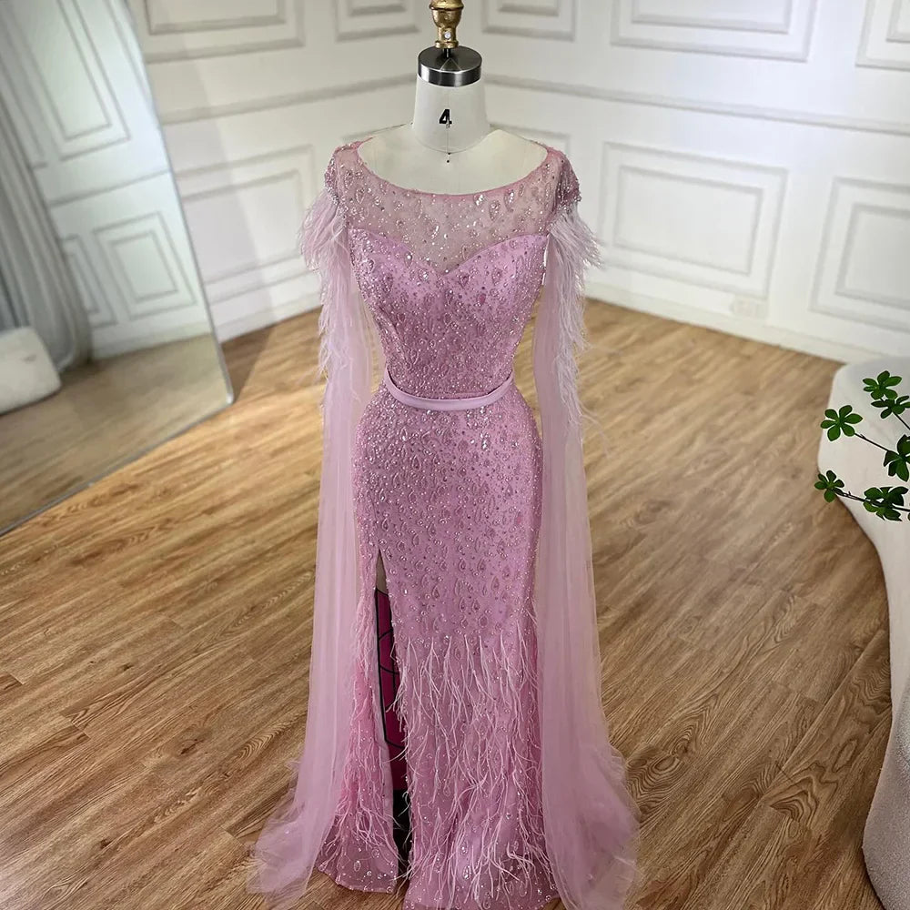 Vestido de noche de sirena con mangas tipo capa rosa estilo Dubai, falda lateral, plumas y cuentas, modelo LA72701 (2025) 