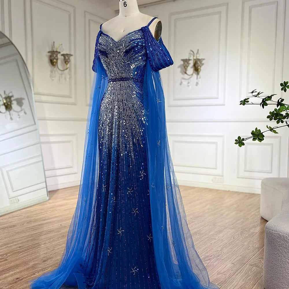 Vestido de noche de lujo estilo sirena azul con tirantes finos y mangas tipo capa, ideal para ocasiones formales (modelo 2025). Fabricado en Arabia Saudita (LA72707). 