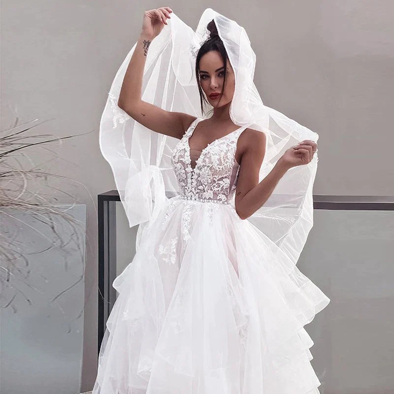 Robe de mariée sexy à décolleté en V et épaules dénudées, blanche, sans manches, style bohème chic, idéale pour une cérémonie de plage ou une fête de mariage. Collection 2023. Robe dos nu.
