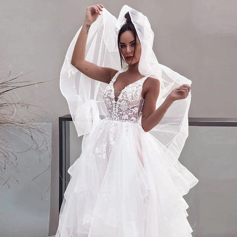 Vestidos de novia blancos sin mangas, estilo bohemio, con escote en V, doble hombro y espalda descubierta. Ideales para bodas formales en la playa. Colección 2023.