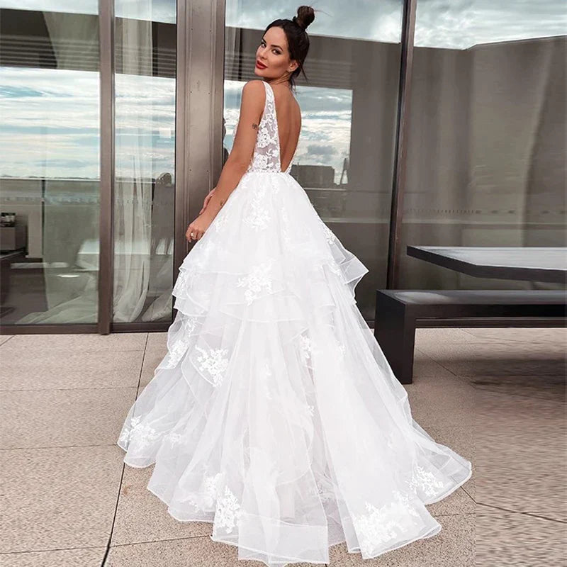 Robe de mariée sexy à décolleté en V et épaules dénudées, blanche, sans manches, style bohème chic, idéale pour une cérémonie de plage ou une fête de mariage. Collection 2023. Robe dos nu.