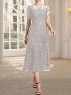 Vestido de novia de encaje con lentejuelas, corte en A, escote redondo ilusión y largo hasta la rodilla.