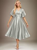 Vestido de novia de satén elástico, corte en A, escote en V, largo hasta la rodilla, con cuentas y pliegues. 