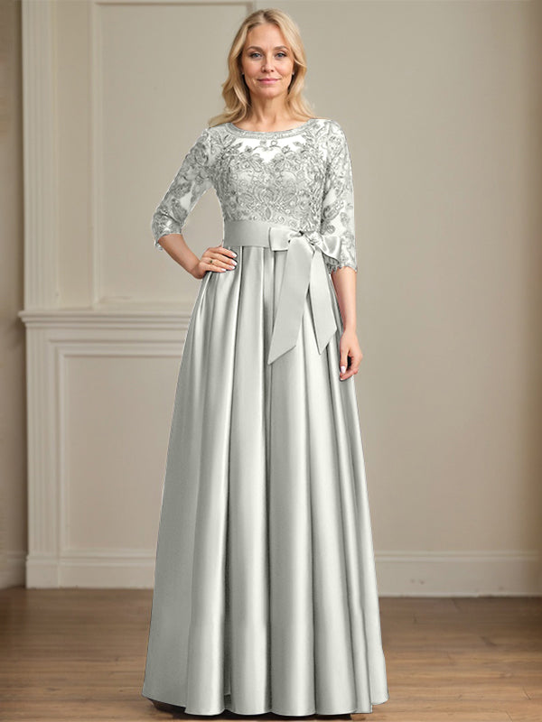 Vestido de novia corte A, escote ilusión, largo hasta el suelo, de satén y encaje, con lazo de lentejuelas. 