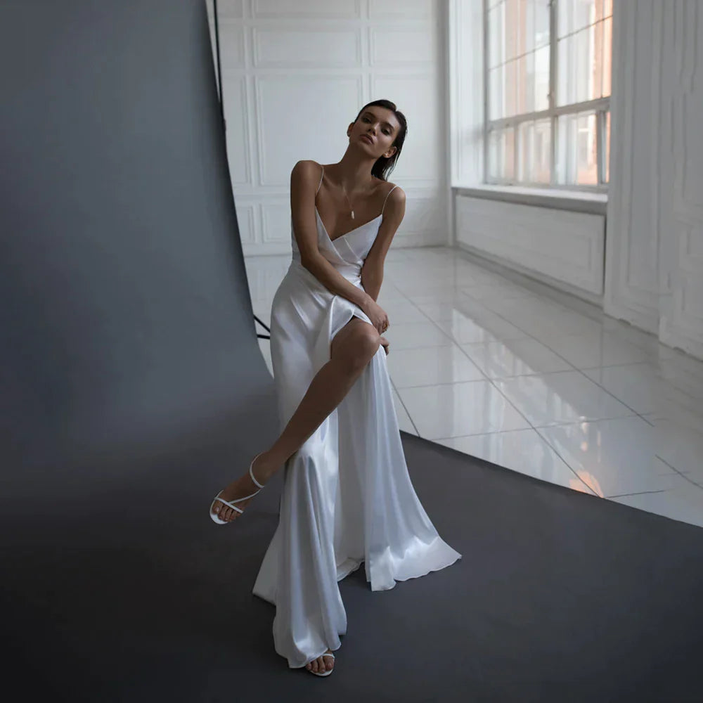 Robe de mariée simple en satin, coupe trapèze, décolleté en V, fines bretelles, dos nu fendu, sur mesure. 