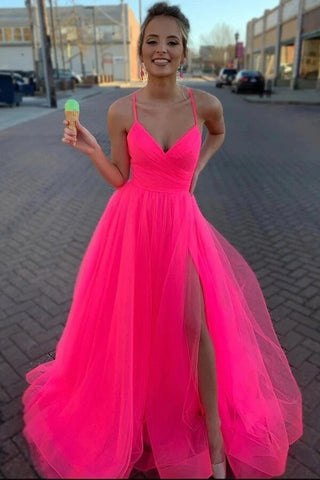 Robe de bal longue et simple en tulle rose fuchsia, coupe trapèze, avec fente.