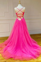 Robe de bal longue et simple en tulle rose fuchsia, coupe trapèze, avec fente.