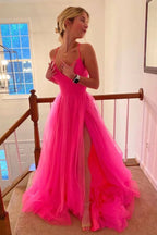 Robe de bal longue et simple en tulle rose fuchsia, coupe trapèze, avec fente.