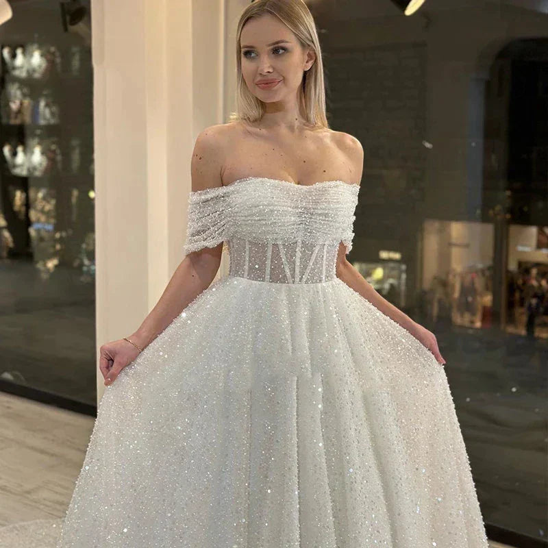 Vestidos de novia nuevos con encaje brillante, escote corazón y hombros descubiertos, espalda descubierta, hermosos apliques y cola de barrido. 