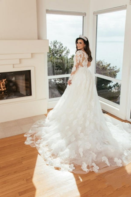 Robe de mariée longue en tulle, coupe trapèze, décolleté en cœur et ornée d'appliques.