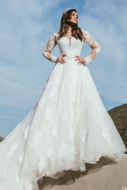 Robe de mariée longue en tulle, coupe trapèze, décolleté en cœur et ornée d'appliques.