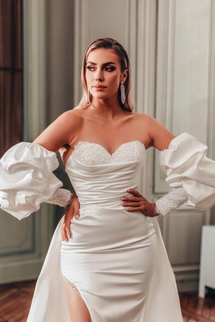 Vestidos de novia de corte A con escote corazón, abertura frontal, manga larga y volantes.