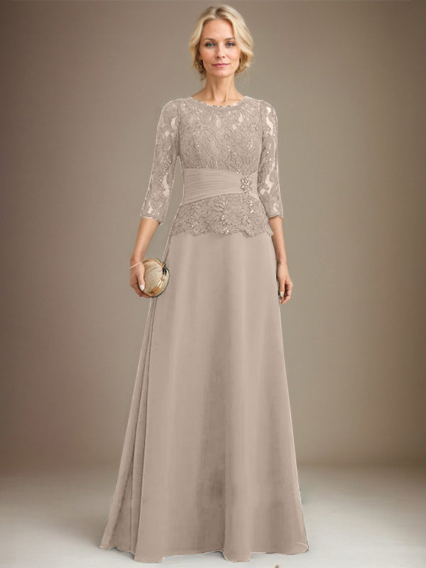 Robe de mariée longue en mousseline de soie et dentelle, coupe trapèze, décolleté illusion, ornée de sequins plissés et de perles. 