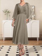 Vestido de corte A, escote en V, largo hasta la rodilla, de gasa, encaje, con lentejuelas y pedrería para la madre de la novia.