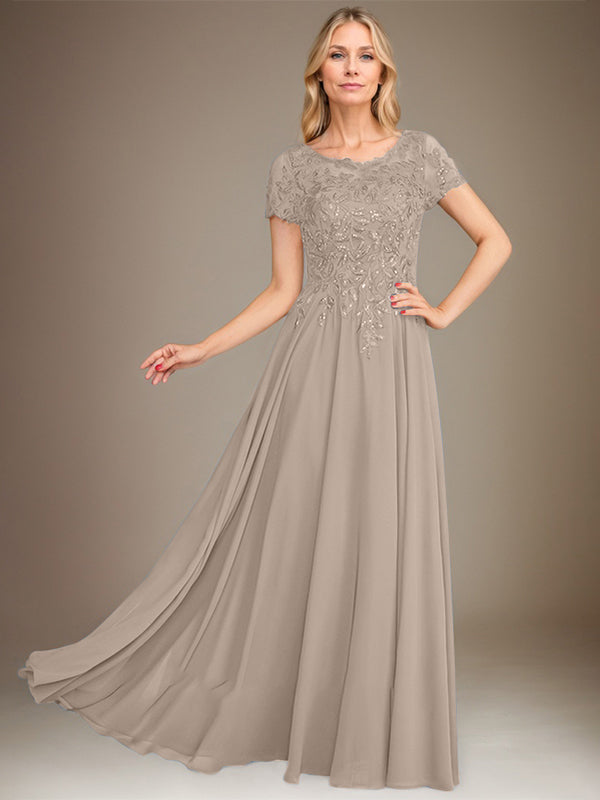 Robe de mariée longue en mousseline de soie, coupe trapèze, décolleté rond, ornée d'appliqués et de sequins, idéale pour la mère de la mariée. 