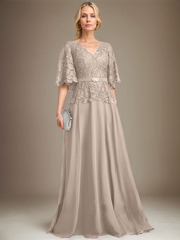 Vestido de novia de corte A, escote en V, largo hasta el suelo, de gasa y encaje, con broche de cristal y pedrería. 