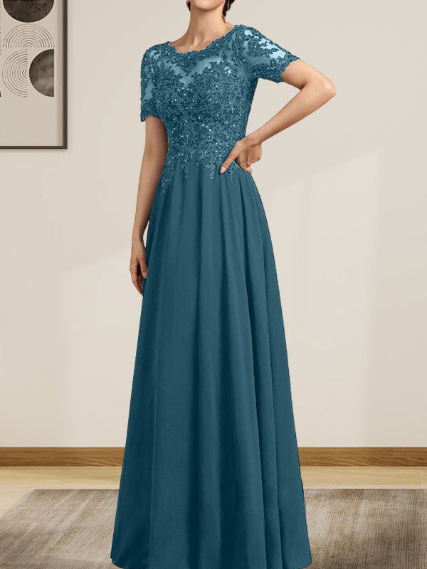 Robe de mariée longue en mousseline de soie et dentelle, coupe trapèze, décolleté illusion, ornée de sequins et de perles.