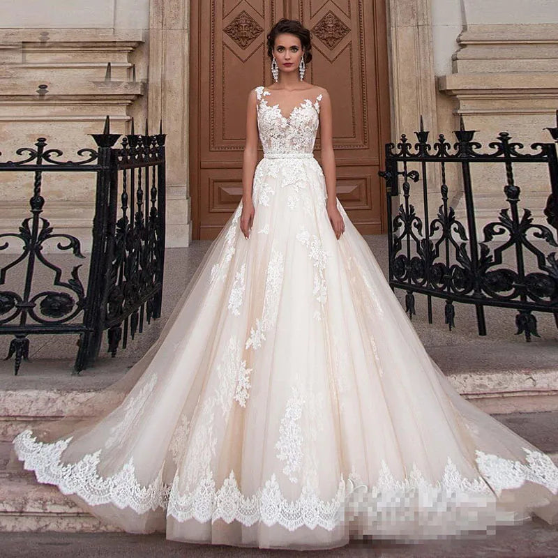 Vestido de novia transparente color champán con cinturón de perlas extraíble, sin mangas, espalda descubierta y encaje (Serie 2023). 