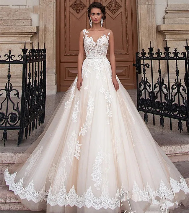 Vestido de novia transparente color champán con cinturón de perlas extraíble, sin mangas, espalda descubierta y encaje (Serie 2023). 