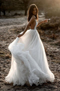 Robe de mariée en tulle, coupe trapèze, décolleté plongeant en V, dos nu et fines bretelles spaghetti
