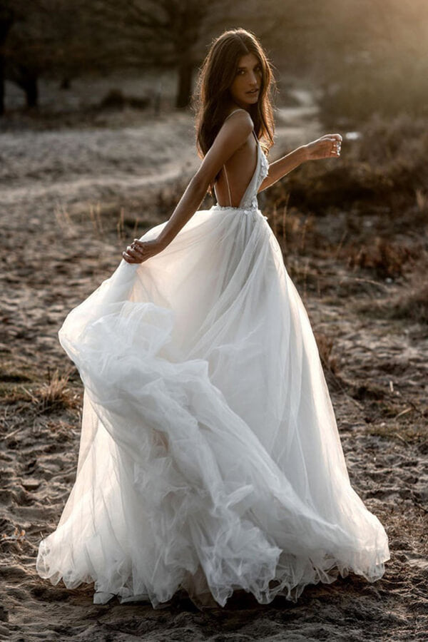 Robe de mariée en tulle, coupe trapèze, décolleté plongeant en V, dos nu et fines bretelles spaghetti