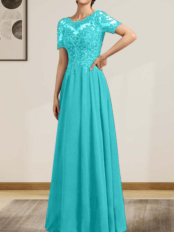 Robe de mariée longue en mousseline de soie et dentelle, coupe trapèze, décolleté illusion, ornée de sequins et de perles.