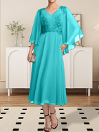 Vestido de corte A, escote en V, largo hasta la rodilla, de gasa, encaje, con lentejuelas y pedrería para la madre de la novia.