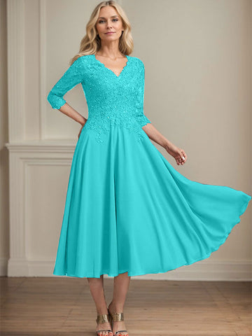 Vestido de corte A, escote en V, largo hasta la rodilla, de gasa, encaje, con lentejuelas y pedrería para la madre de la novia. 