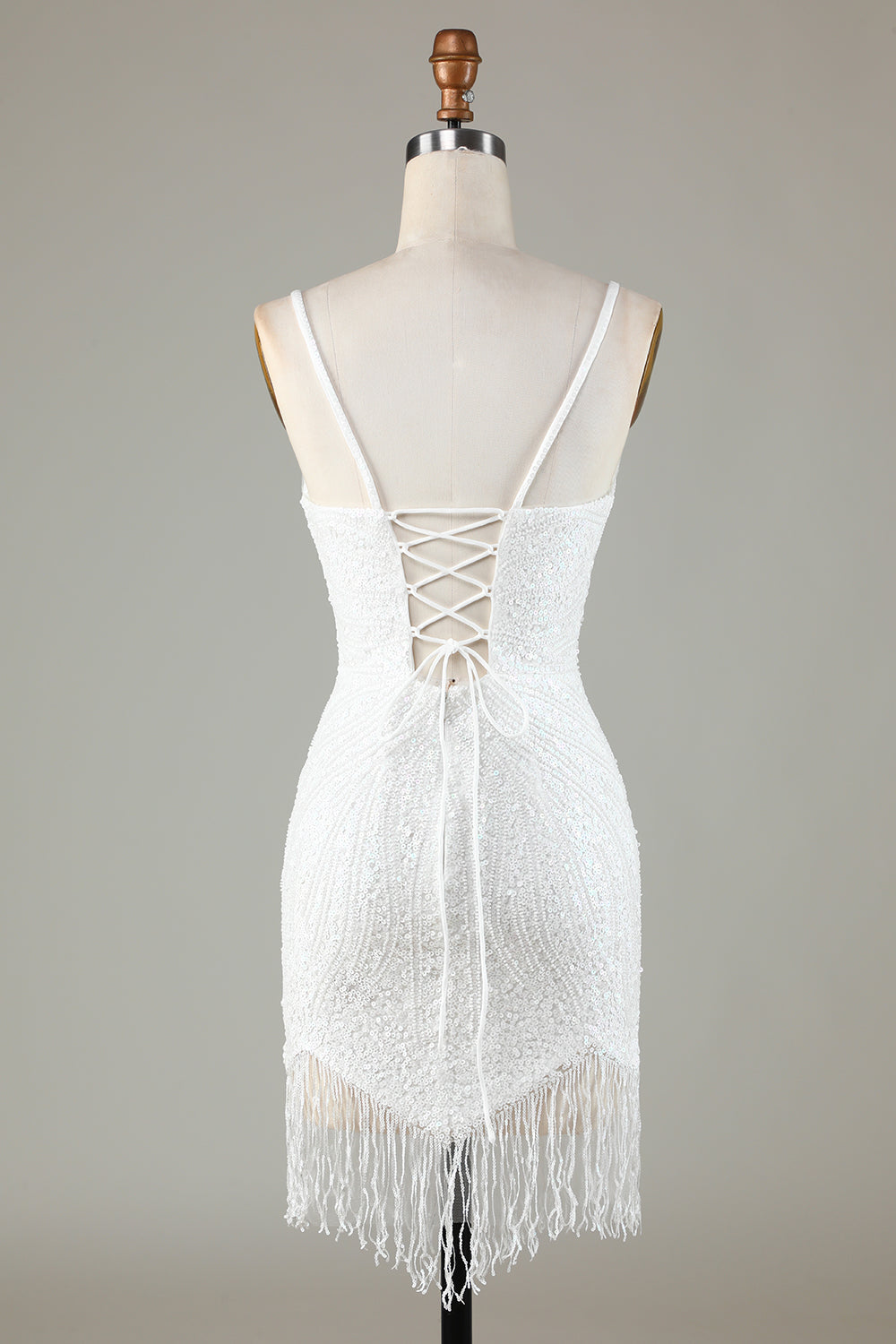 Robe de bal courte blanche scintillante à lacets dans le dos, ornée de perles et de pompons.