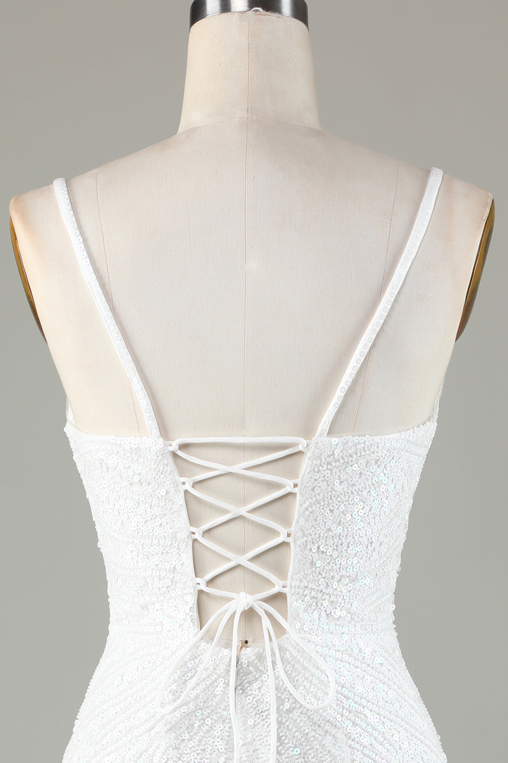 Robe de bal courte blanche scintillante à lacets dans le dos, ornée de perles et de pompons.