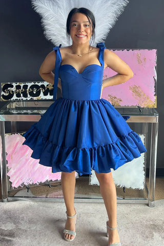 Robe de bal courte rose fuchsia à fines bretelles spaghetti et coupe princesse, ornée de fronces.