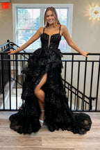 Robe de bal longue à fines bretelles pailletées, coupe trapèze, corset à volants et fente, ornée de sequins.