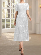 Vestido de novia de encaje con lentejuelas, corte en A, escote redondo ilusión y largo hasta la rodilla.