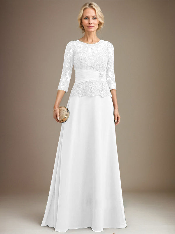 Robe de mariée longue en mousseline de soie et dentelle, coupe trapèze, décolleté illusion, ornée de sequins plissés et de perles. 