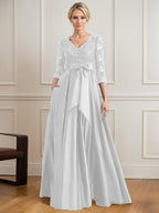 Vestido de novia de satén con encaje, corte en A, escote en V y largo hasta el suelo, con lazo de lentejuelas. 