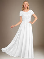 Robe de mariée longue en mousseline de soie, coupe trapèze, décolleté rond, ornée d'appliqués et de sequins, idéale pour la mère de la mariée. 