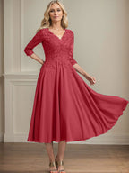 Vestido de corte A, escote en V, largo hasta la rodilla, de gasa, encaje, con lentejuelas y pedrería para la madre de la novia. 