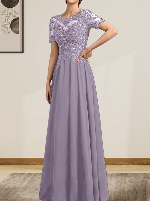 Robe de mariée longue en mousseline de soie et dentelle, coupe trapèze, décolleté illusion, ornée de sequins et de perles.