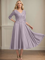 Vestido de corte A, escote en V, largo hasta la rodilla, de gasa, encaje, con lentejuelas y pedrería para la madre de la novia. 