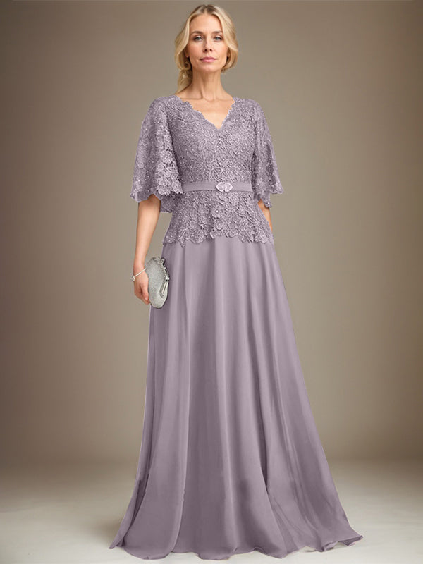 Vestido de novia de corte A, escote en V, largo hasta el suelo, de gasa y encaje, con broche de cristal y pedrería. 