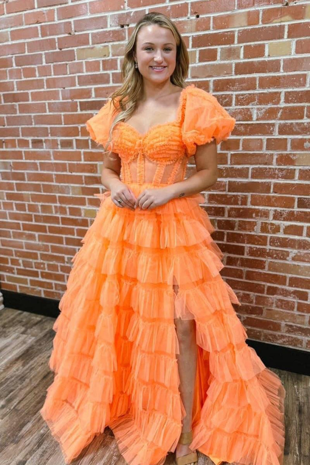 Robe de bal longue en tulle à épaules dénudées, coupe trapèze, bustier à volants et fente.