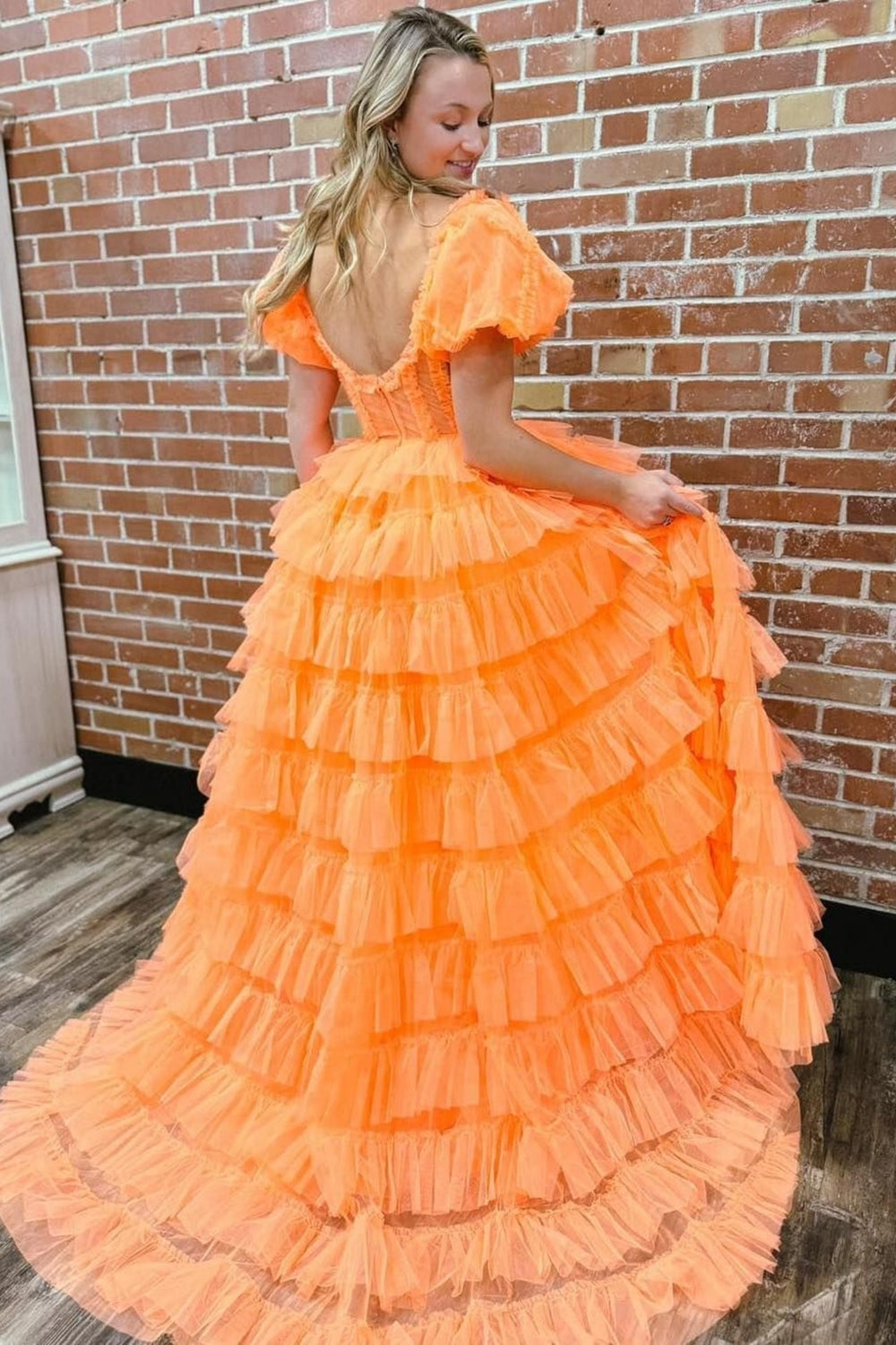 Robe de bal longue en tulle à épaules dénudées, coupe trapèze, bustier à volants et fente.